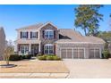 Charming two-story home with a stone facade, three-car garage, and well-manicured lawn at 496 Spring View Dr, Woodstock, GA 30188