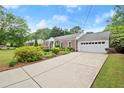 Brick home with a well-kept lawn, mature landscaping, concrete driveway and an attached two-car garage at 1000 Grimes Bridge Rd, Roswell, GA 30075