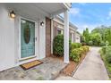 Inviting front entryway of a brick home featuring a decorative blue door, tile, and lush landscaping at 1000 Grimes Bridge Rd, Roswell, GA 30075