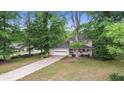 Beautiful home with mature trees, well-maintained lawn, and a long driveway leading to the two-car garage at 15 Ashton Pl, Covington, GA 30016
