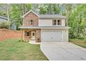 Charming two-story home featuring a stone facade, light siding, and an attached two-car garage in a lush, wooded setting at 191 Davis Ct, Hiram, GA 30141