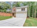 Charming two-story home featuring a stone facade, light siding, and an attached two-car garage in a lush, wooded setting at 191 Davis Ct, Hiram, GA 30141