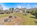 Spacious backyard offers outdoor living space with stone fire pit, table with umbrella, and wooden privacy fence at 2767 Camp Mitchell Rd, Loganville, GA 30052