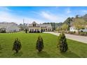 A single-Gathering home featuring a large manicured lawn, inviting curb appeal, and symmetrical window placement at 2767 Camp Mitchell Rd, Loganville, GA 30052
