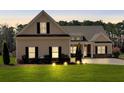 Charming single-Gathering home at dusk featuring manicured lawn, inviting curb appeal, and symmetrical window placement at 2767 Camp Mitchell Rd, Loganville, GA 30052