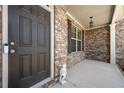 Close-up of a covered front porch with brick facade and a decorative front door at 5465 Mirror Lake Dr, Cumming, GA 30028