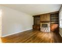 Cozy living room featuring hardwood floors, a wood-paneled fireplace, and custom built-in shelving at 2757 Shelley Ln, Ellenwood, GA 30294