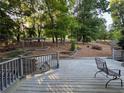 Wood deck with gray railings and outdoor seating overlooking the tree-lined backyard at 990 Azalea Dr, Roswell, GA 30075