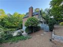 Exterior view of a two-story house with a brick chimney, gray siding, and a deck at 990 Azalea Dr, Roswell, GA 30075