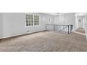 Bright living room featuring neutral paint, cozy carpet, and large windows offering ample natural light at 6307 Thornhedge Dr, Riverdale, GA 30296