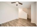 Empty bedroom with gray wood-look floors and a ceiling fan, leading to the staircase at 33 Oxford Ln, Kingston, GA 30145