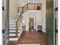 Bright and inviting foyer featuring hardwood floors, a modern staircase, and an open layout at 9950 Farmbrook Ln, Johns Creek, GA 30022
