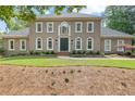Elegant home with beautiful landscaping, a symmetrical facade, and a welcoming entrance at 9950 Farmbrook Ln, Johns Creek, GA 30022