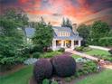 Beautiful home showcasing professional landscaping, charming covered porch, and a lush green lawn at 11660 Crabapple Rd, Roswell, GA 30075