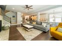 Open concept living room with hardwood floors, a cozy fireplace, and an adjacent staircase at 155 Marlow Dr, Woodstock, GA 30188