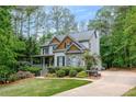 Two-story home with a stone accent wall, lush landscaping, and a long driveway at 529 Wintergreen Way, Canton, GA 30115
