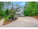 Side exterior view of a two-story home showing a garage and a long driveway at 529 Wintergreen Way, Canton, GA 30115
