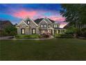 Beautiful brick home at dusk featuring a well-maintained lawn and manicured landscaping at 146 Cedar Woods Trl, Canton, GA 30114