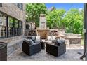 Outdoor brick fireplace with seating area and built-in grill perfect for entertaining guests at 146 Cedar Woods Trl, Canton, GA 30114