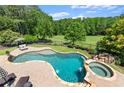 Aerial view of a backyard pool and hot tub with beautiful landscaping and a lush green golf course at 146 Cedar Woods Trl, Canton, GA 30114