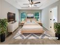 Serene main bedroom with tray ceiling, plush carpet, TV, and natural light at 6001 Oak Bend Ct, Riverdale, GA 30296