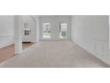 Spacious living room featuring neutral carpeting, white walls, and large windows at 3208 Juniper Nw Dr, Kennesaw, GA 30144