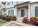Townhouse entrance with well-maintained landscaping and rose flowerbeds leading to front door at 7762 Fawn Cir, Covington, GA 30014