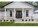 Inviting front porch with double doors, white columns, and decorative stone walkway at 4439 Luther Ward Rd, Powder Springs, GA 30127