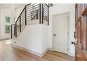 Bright foyer featuring sleek black metal stair railing, light wood floors, and a white door at 2934 Wendover St, Marietta, GA 30062