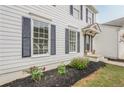 Side view of a white house with dark shutters, a well-maintained garden, and a welcoming entrance at 303 Cimarron Way, Lawrenceville, GA 30044
