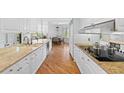 Bright kitchen with white cabinetry, granite counters, stainless appliances, and a view into the dining area at 2660 Peachtree Rd # 7F, Atlanta, GA 30305