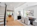 Bright dining room with modern chandelier, white chairs, and an adjacent staircase at 50 Maple St, Roswell, GA 30075