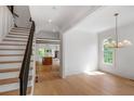 Bright entryway featuring hardwood floors, white trim, staircase with iron railing, and natural light at 50 Maple St, Roswell, GA 30075