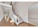 Grand foyer with hardwood floors, staircase with wrought iron railing, and access to multiple living areas at 105 Tanners Ct, Covington, GA 30016
