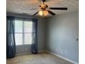 A bedroom with a ceiling fan, a large window with curtains, and carpeted floors at 14301 Waldrop Cv, Decatur, GA 30034