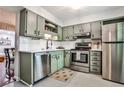 Updated kitchen features stainless steel appliances and stylish green cabinetry with modern hardware at 2474 Lehaven Dr, Tucker, GA 30084