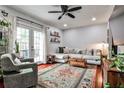 Sunlit living room featuring a plush sectional sofa, a stylish rug, and French doors to outside at 2474 Lehaven Dr, Tucker, GA 30084