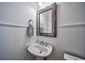 Cozy powder room with a pedestal sink, decorative mirror, and wainscoting at 57 Forsyth Nw St # 12B, Atlanta, GA 30303