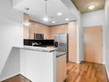Cozy kitchen with stainless steel appliances, wood cabinets, breakfast bar, and hardwood floors at 860 Peachtree Ne St # 909, Atlanta, GA 30308