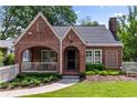 Charming brick Tudor home features a covered porch and a lush, well-manicured front lawn at 97 Peachtree Hills Ne Ave, Atlanta, GA 30305