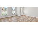 Flex space with light wood floors, two large windows and a door to the exterior at 205 Kindness Cir, Mcdonough, GA 30252