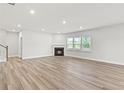 Open living room with light wood floors, fireplace, and lots of natural light at 205 Kindness Cir, Mcdonough, GA 30252
