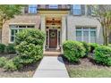 Inviting townhome entryway with lush landscaping and covered porch at 7725 Pierpoint Ln, Alpharetta, GA 30005