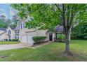 Two-story home with a well-manicured lawn, front shrubbery, and a two-car garage at 2319 Rambling Way, Lithonia, GA 30058