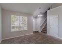 Bright living room with neutral paint, plush carpet, and natural light from the window at 2319 Rambling Way, Lithonia, GA 30058