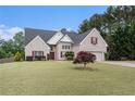 Charming brick home featuring a well-manicured lawn and attached two car garage at 25 Skylar Dr, Covington, GA 30016