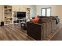 Bright living room with hardwood floors, built-in shelving, and a cozy couch at 3785 Newbury Place Dr, Loganville, GA 30052
