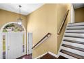 Bright foyer with hardwood floors, staircase, and elegant light fixture at 405 Maple Rdg, White, GA 30184
