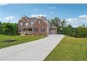 Beautiful two-story brick home with well-manicured lawn and long driveway at 6375 Haystack Ct, Cumming, GA 30040