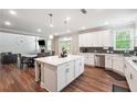 Well-lit kitchen with a central island, stainless steel appliances, and an adjacent dining area at 6375 Haystack Ct, Cumming, GA 30040